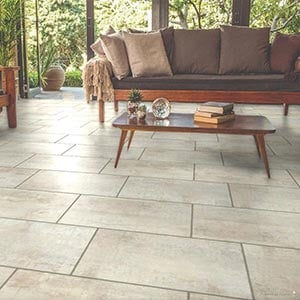 Beige patio tiles with a table and sofa