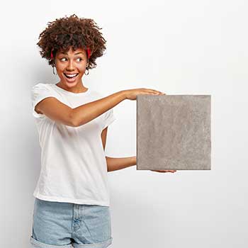 Smiling woman holding a small tile